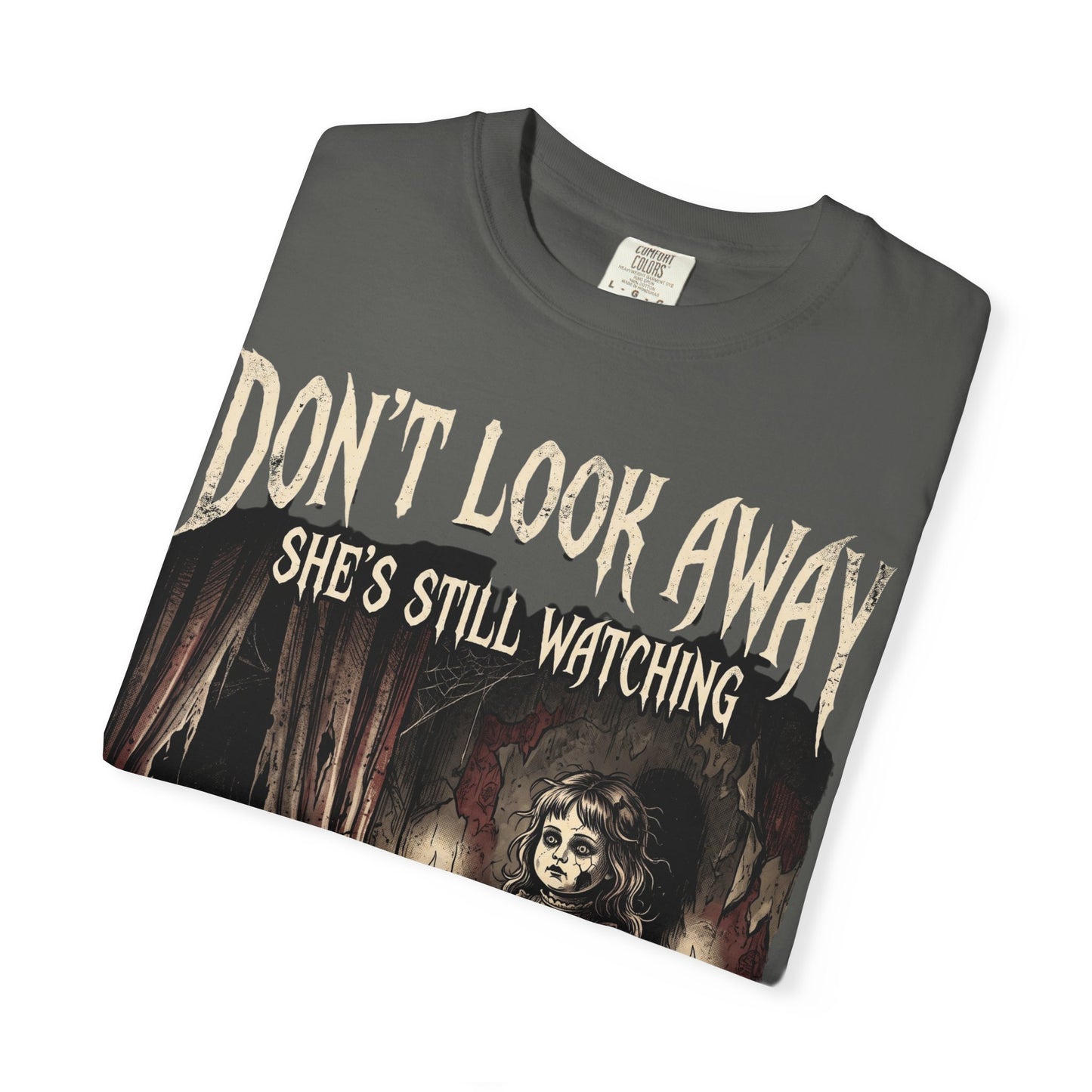 Horror Tee — "Don't Look Away, She's Still Watching" Creepy Doll Graphic T-Shirt